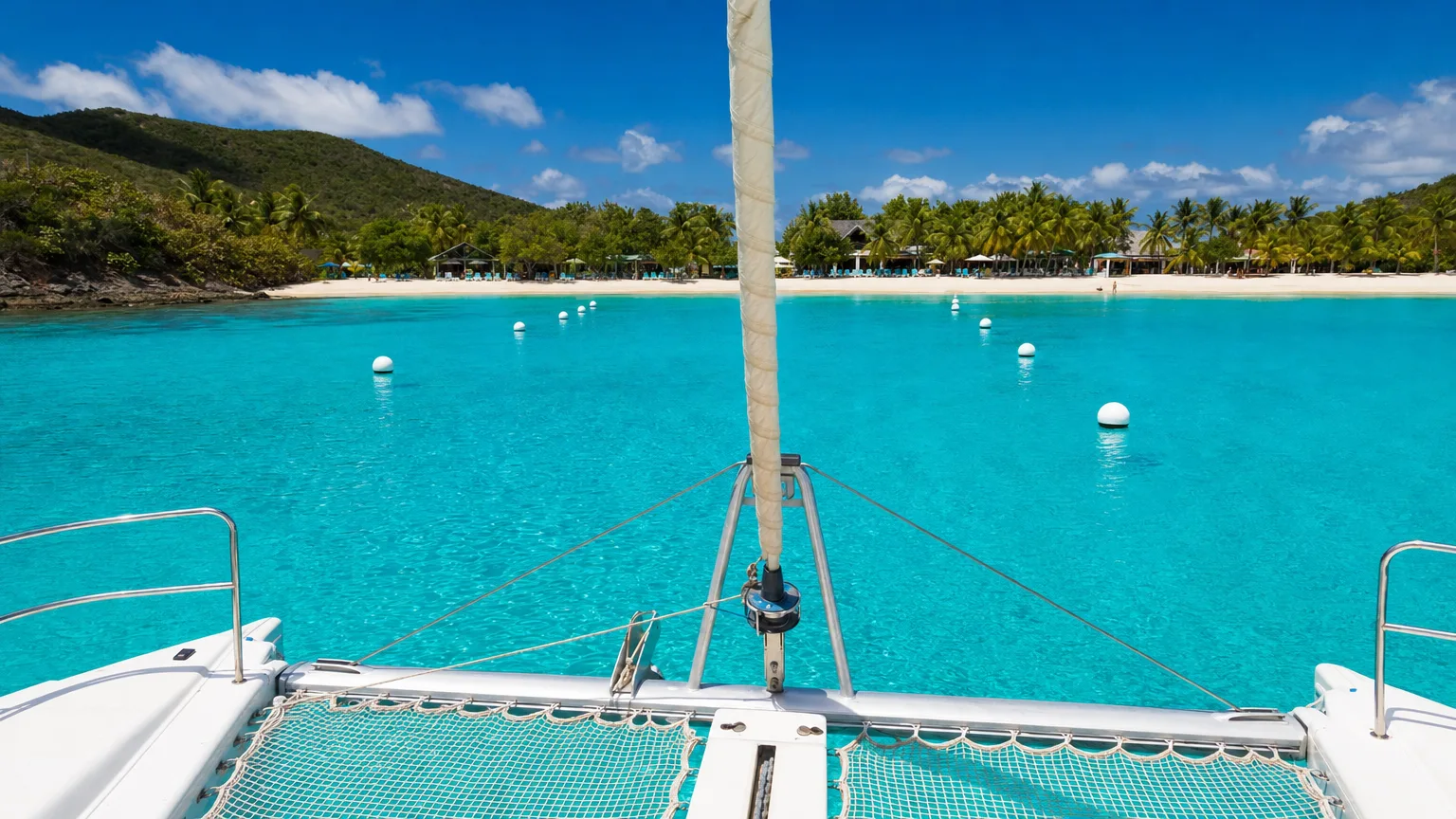 Crewed catamaran approaching the mooring field at White Bay, BVI