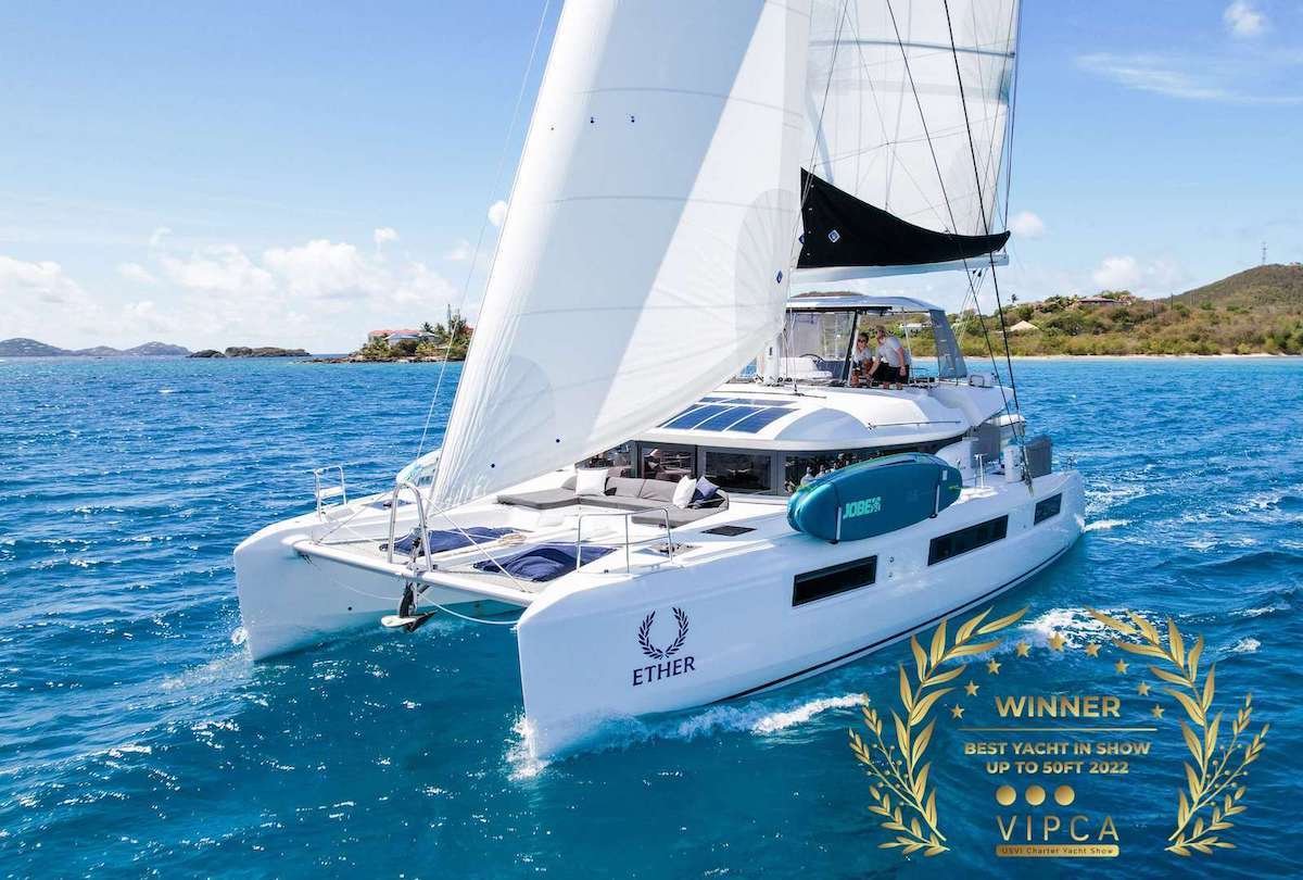 White sailing catamaran Ether on blue sea with sails raised; award badge 'Winner Best Yacht in Show up to 50ft 2022' overlay.