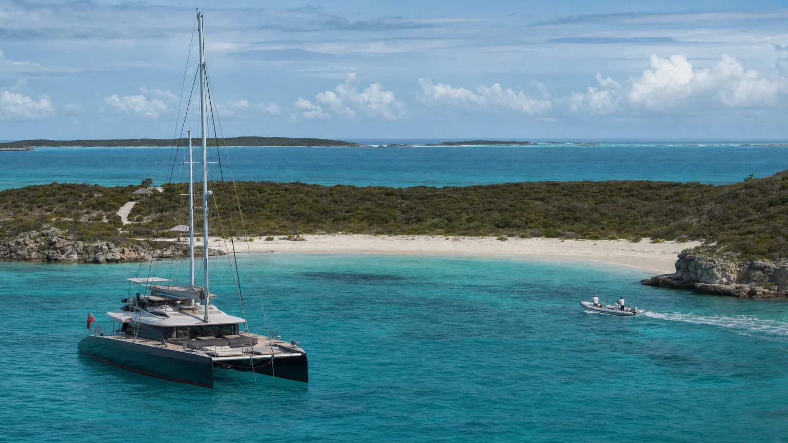 A crewed catamaran anchored in the calm turquoise protected harbour at Compass Cay in the Exumas