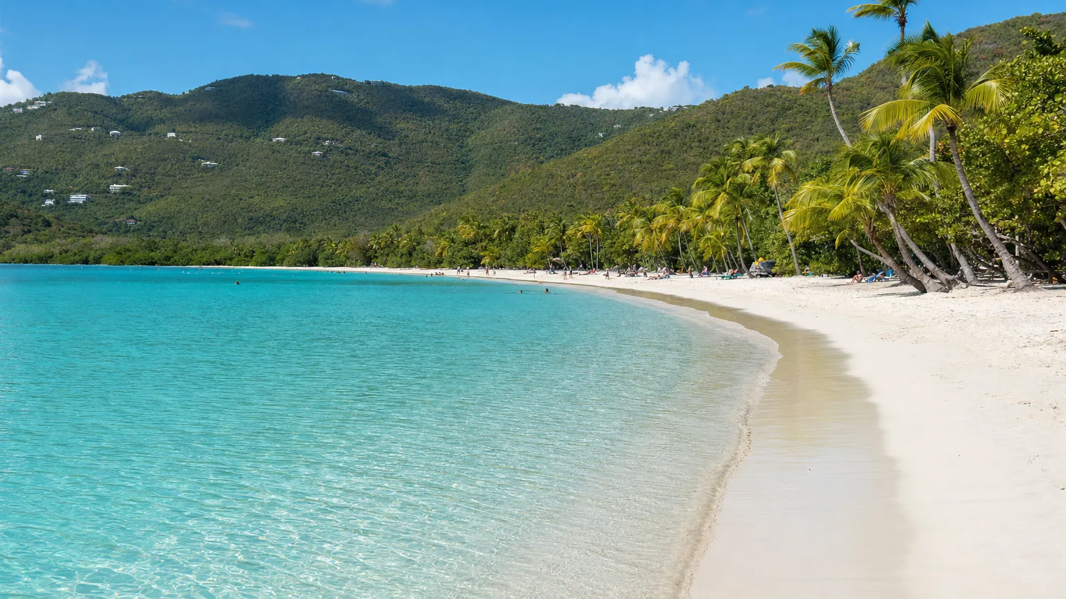 Wide view of the heart-shaped white sand beach and calm turquoise water at Magens Bay, St. Thomas