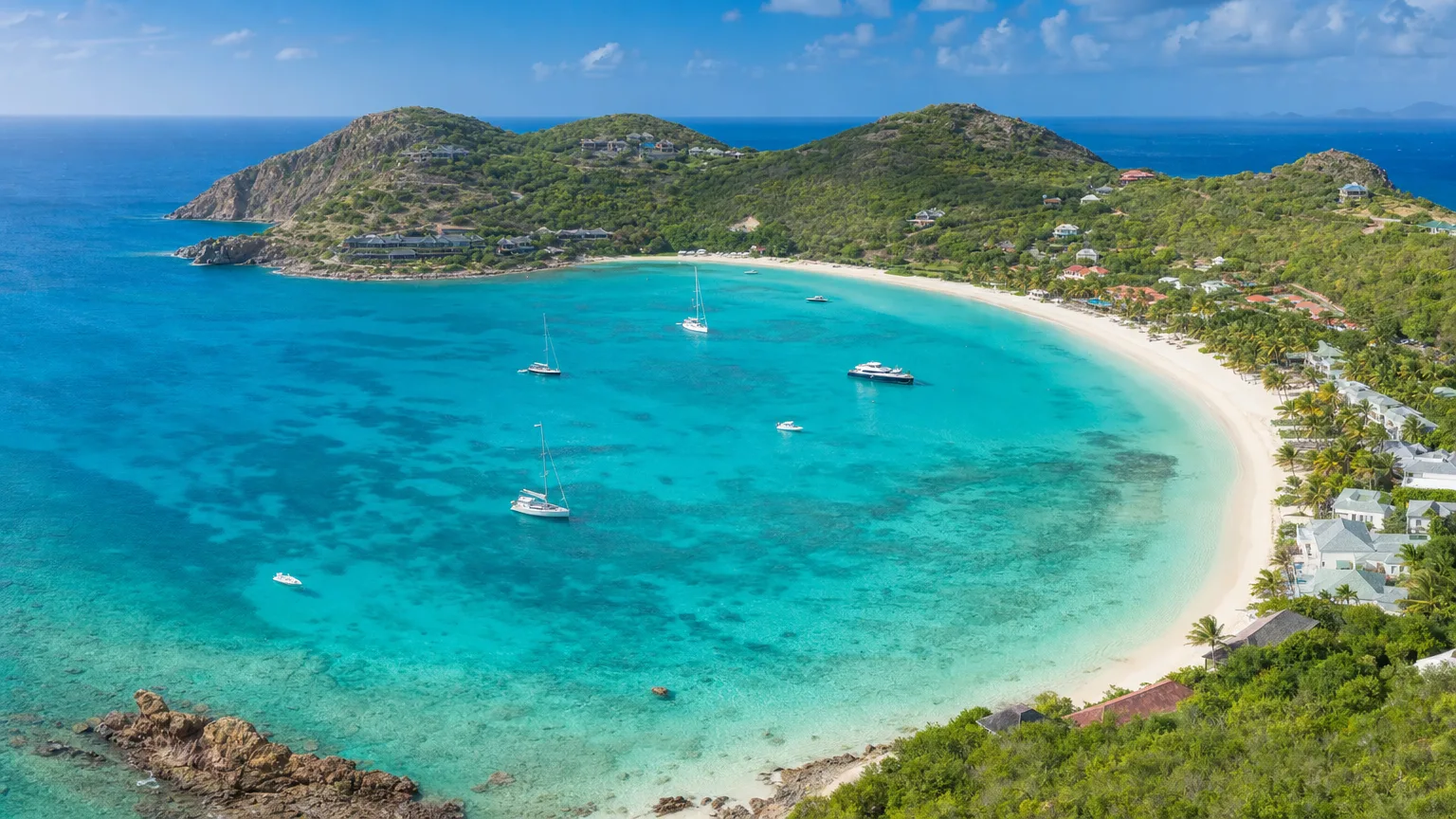 Aerial of Baie de Saint-Jean St. Barts with a white-sand beach turquoise water and green hills