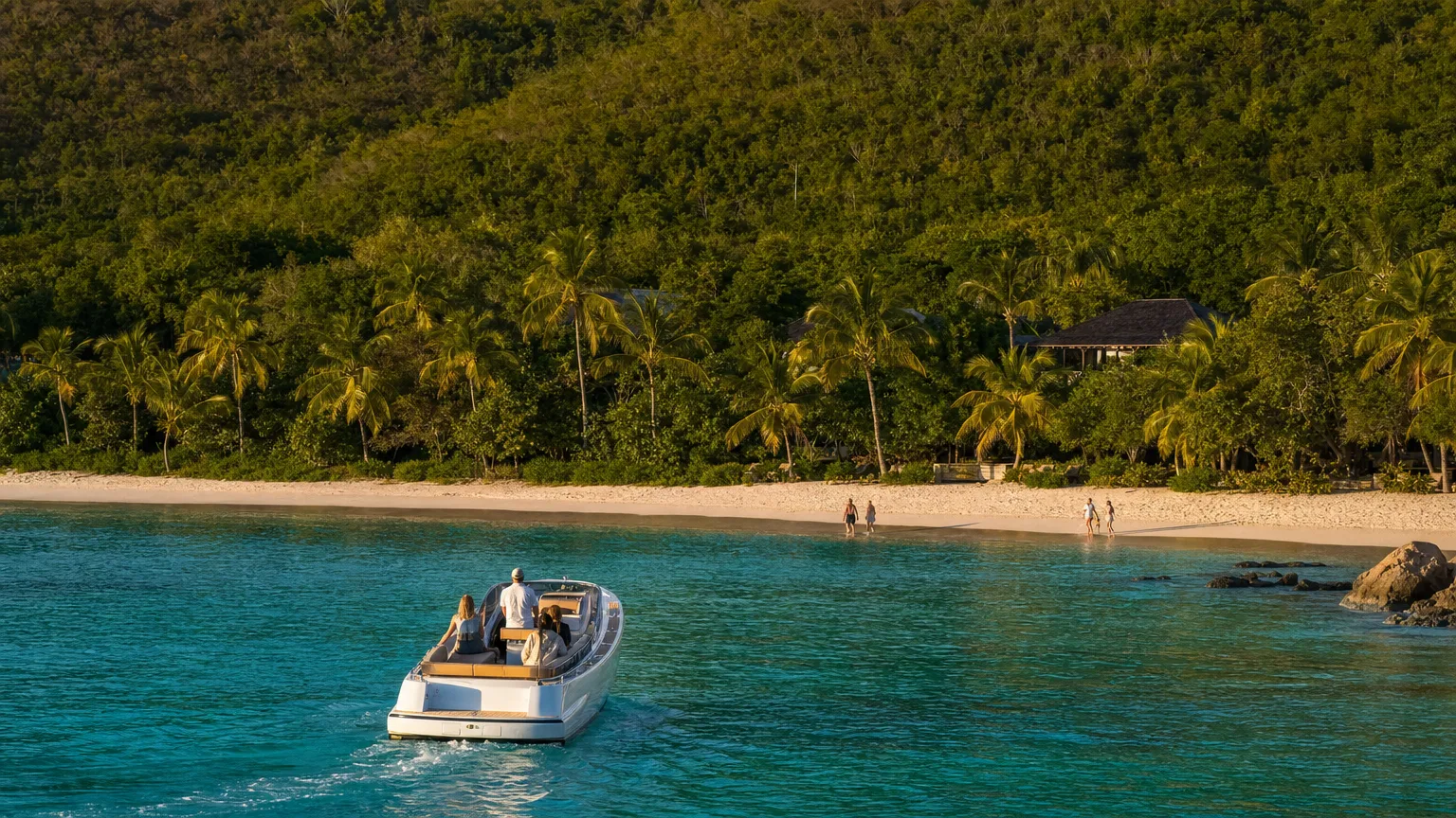 Yacht tender approaching a quiet Caribbean beach at golden hour on St. John in the US Virgin Islands