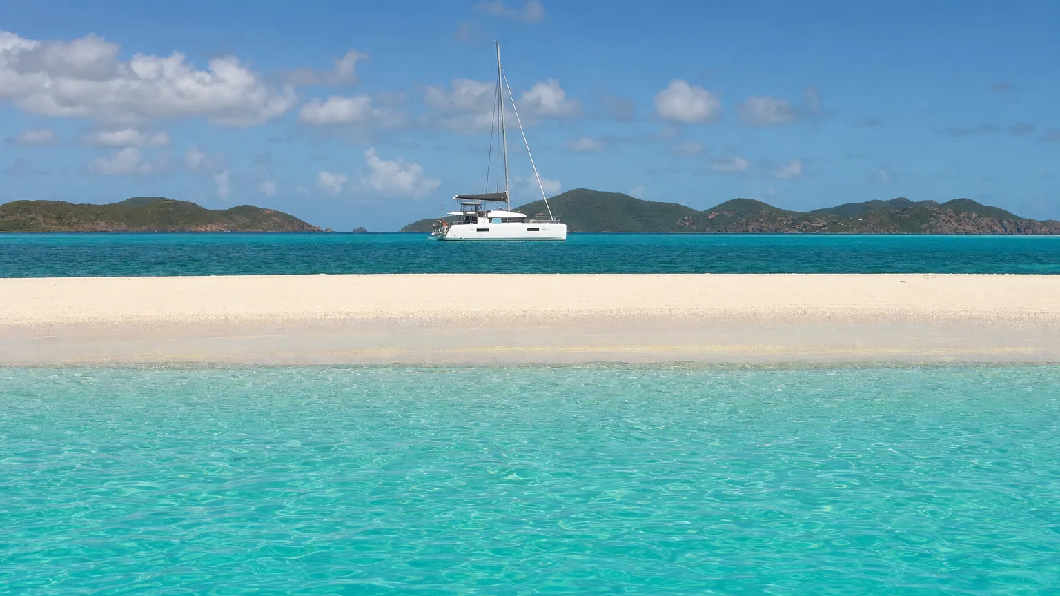 Yacht anchored off the bare sand of Mopion Island in the southern Grenadines