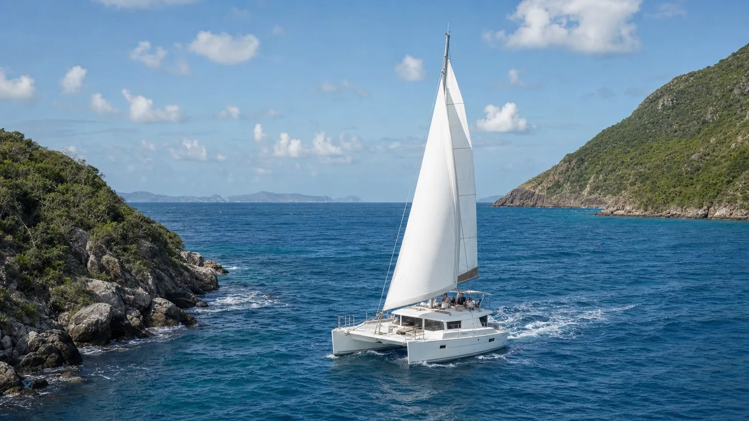 Catamaran under sail between Caribbean islands on an all-inclusive charter week