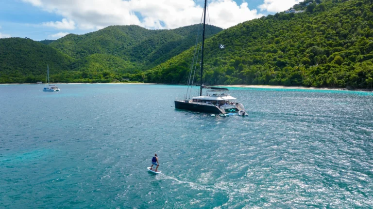 eFoil rider beside the charter catamaran MAHASATTVA in the British Virgin Islands