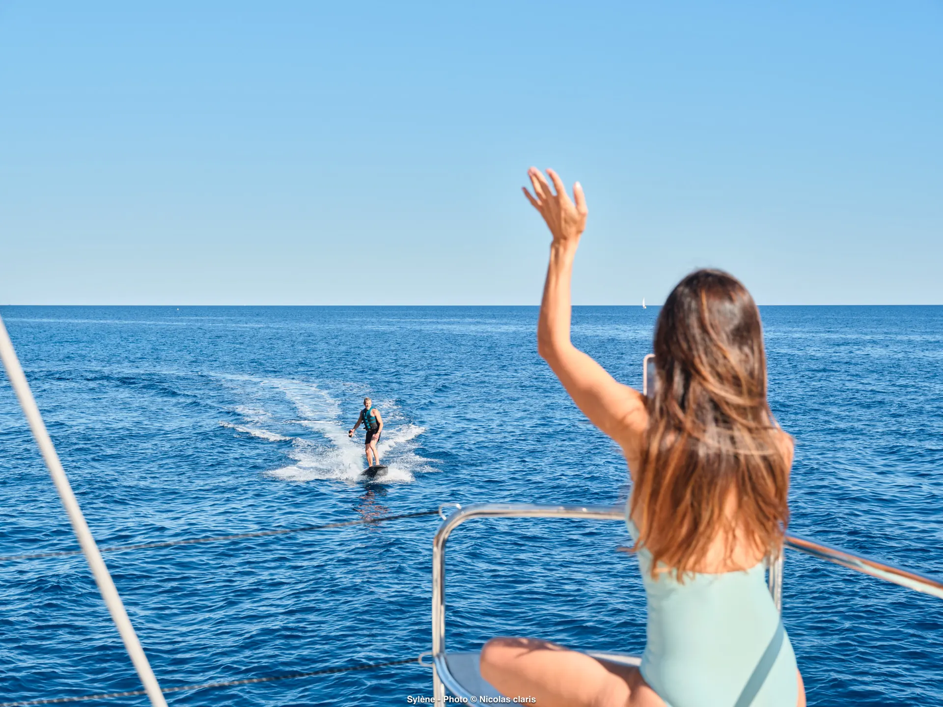 Guest waving from SYLENE to an eFoil rider