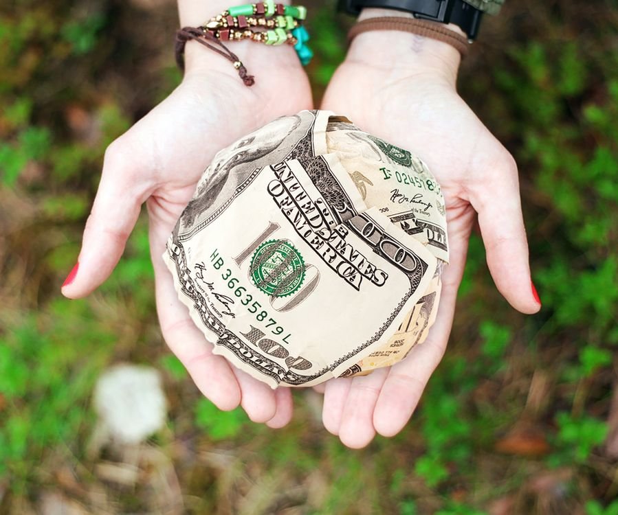 US dollar banknotes fanned in a hand, the cash most guests use to tip yacht crew