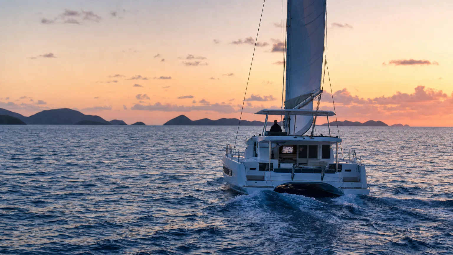 Catamaran on a dawn repositioning passage, the trip a yacht charter delivery fee pays for