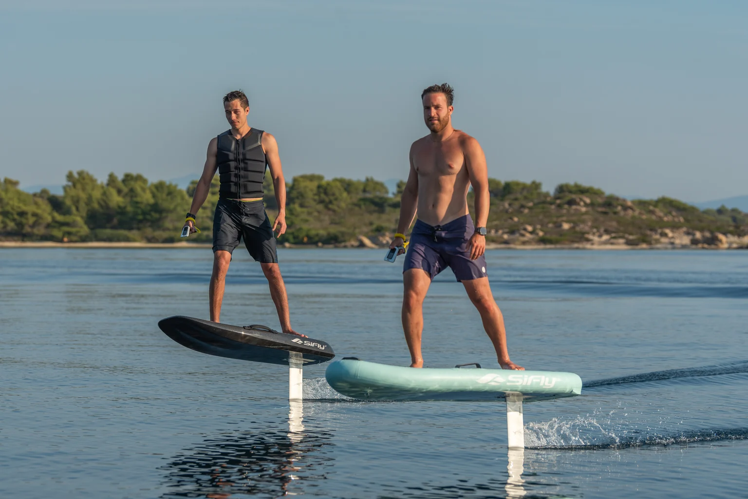Two riders side by side on SiFly eFoils, both boards flying above the water on their hydrofoils
