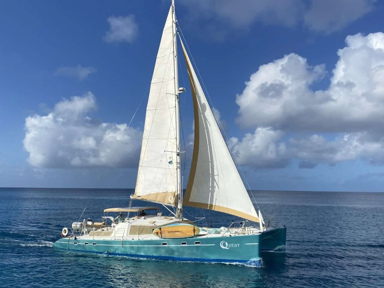Quest is a custom-built 1991 Alex Simonis catamaran that is equally at home voyaging through open ocean swell or being an adventure platform in a secluded bay. She is a drop-dead gorgeous boat that turns heads wherever she goes.
Her airy interior is inviting, with plenty of light to compliment the grain of the well-appointed wood. Her staterooms exhibit all the comforts of home, with plush bedding and cozy nooks that make it hard to get up in the morning. With ample seating around tables in the salon and cockpit, Quest is the perfect place to relax, socialize, or party. There is even space for yoga or launching a kite.
Sailing remarkably well, Quest dances through the waves. She is a joy to sail, and brings smiles to the faces of even the most experienced sailors. She is also incredibly safe, making her the perfect boat for families and first-time sailors alike.
Quest is truly a wonder to behold. She is a work of art, a dream come true, and an absolute joy to sail. If you are looking for an unforgettable sailing experience, then Quest is the boat for you.