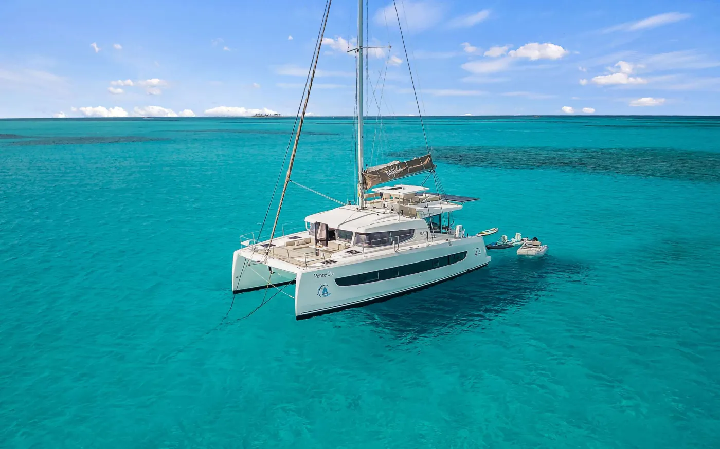 PENNY JO is a 2022 44’ Bali sailing catamaran designed for bright, breezy charters with Bali’s signature indoor-outdoor lifestyle. Sleeps up to 6 in 3 spacious Queen cabins, each with a private ensuite and individual A/C control. The cockpit is made for easy island days with dining for 6 and a lounge bench, while the flybridge delivers 360° views and a front-row seat to the sails. Up front, the solid foredeck adds another favorite hangout with seating and a table—perfect for a book, sea breeze, and sundown cocktails. The highlight is Bali’s tilt-and-turn rear salon wall: open it up and the salon becomes one seamless space with the aft deck for effortless entertaining. Light-filled, social, and beautifully livable—PENNY JO makes every day feel like the best day.