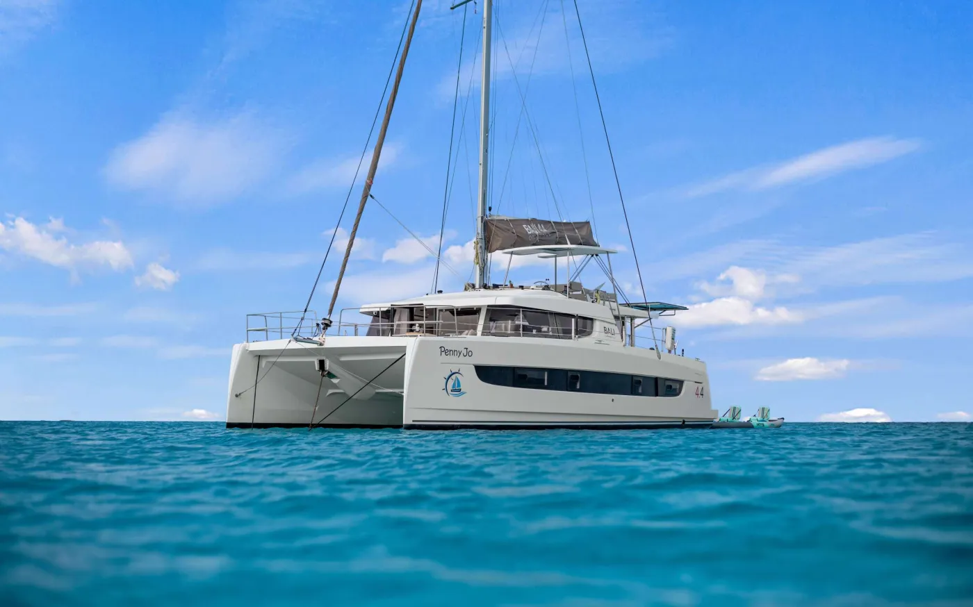 PENNY JO is a 2022 44’ Bali sailing catamaran designed for bright, breezy charters with Bali’s signature indoor-outdoor lifestyle. Sleeps up to 6 in 3 spacious Queen cabins, each with a private ensuite and individual A/C control. The cockpit is made for easy island days with dining for 6 and a lounge bench, while the flybridge delivers 360° views and a front-row seat to the sails. Up front, the solid foredeck adds another favorite hangout with seating and a table—perfect for a book, sea breeze, and sundown cocktails. The highlight is Bali’s tilt-and-turn rear salon wall: open it up and the salon becomes one seamless space with the aft deck for effortless entertaining. Light-filled, social, and beautifully livable—PENNY JO makes every day feel like the best day.