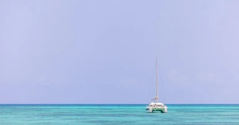 Sailboat at anchor on crystal-clear turquoise water in Antigua, a typical Caribbean yacht charter setting